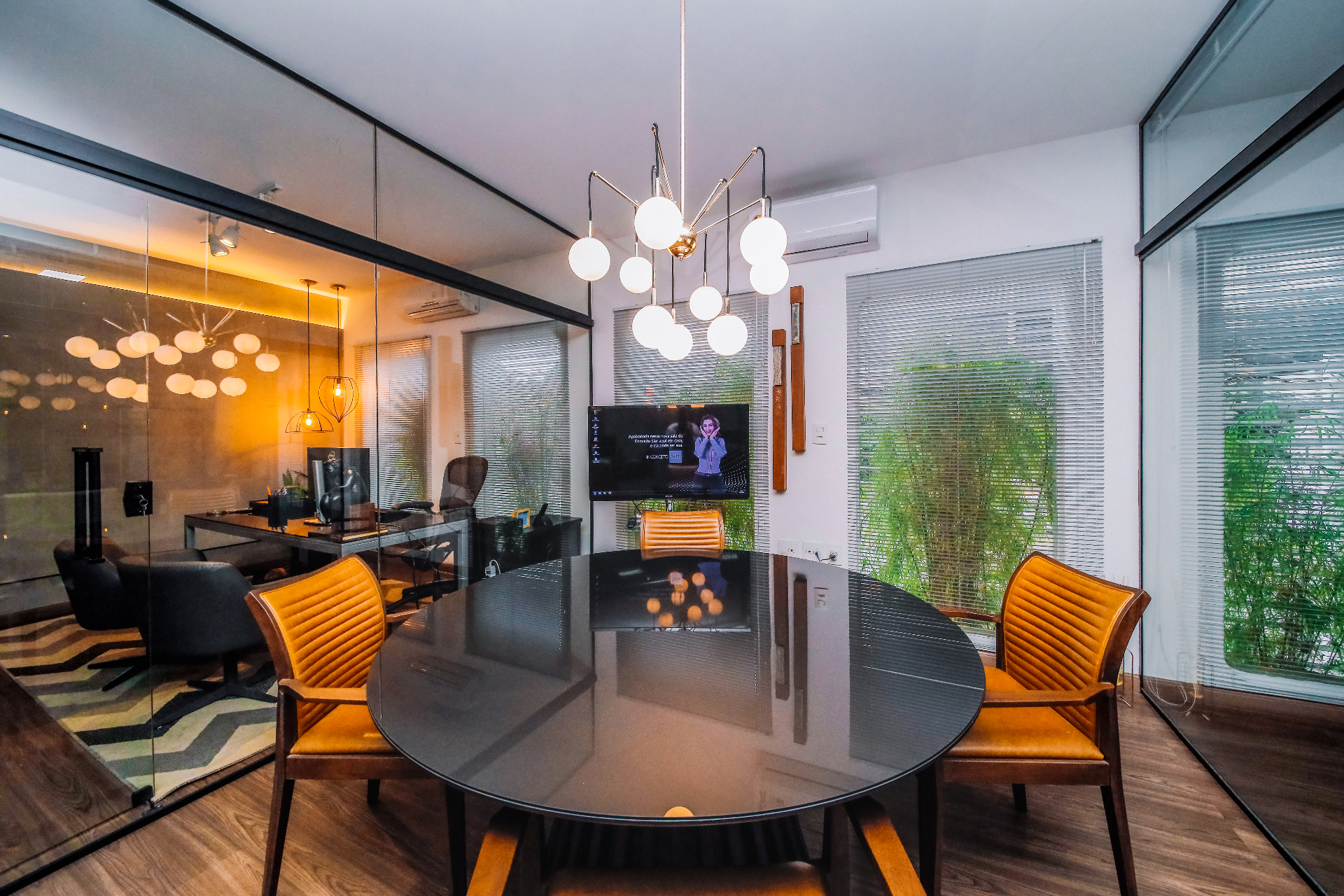 Sala de reunião com mesa redonda e luminária escultural
