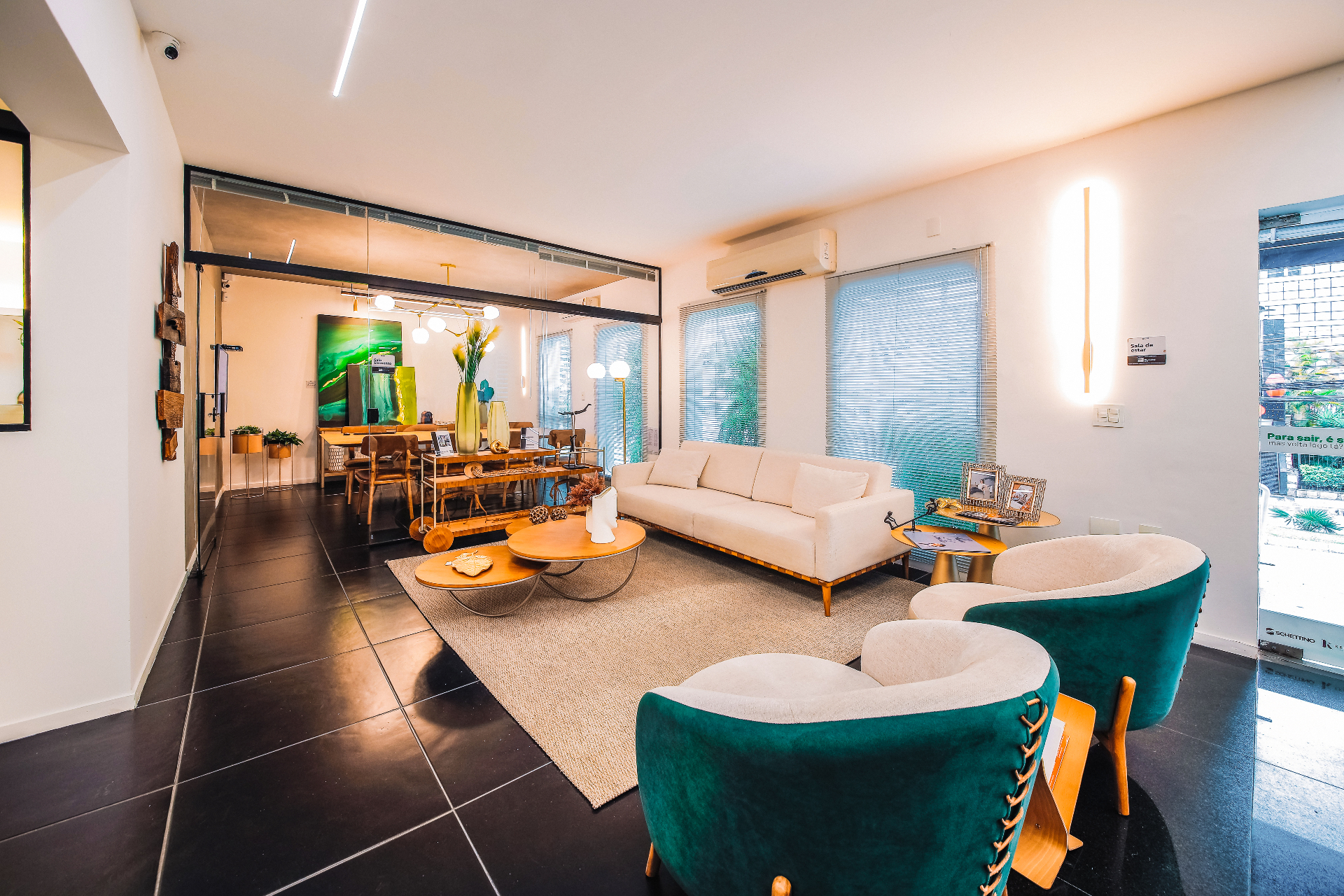 Sala de estar com poltronas verde-esmeralda e iluminação cênica